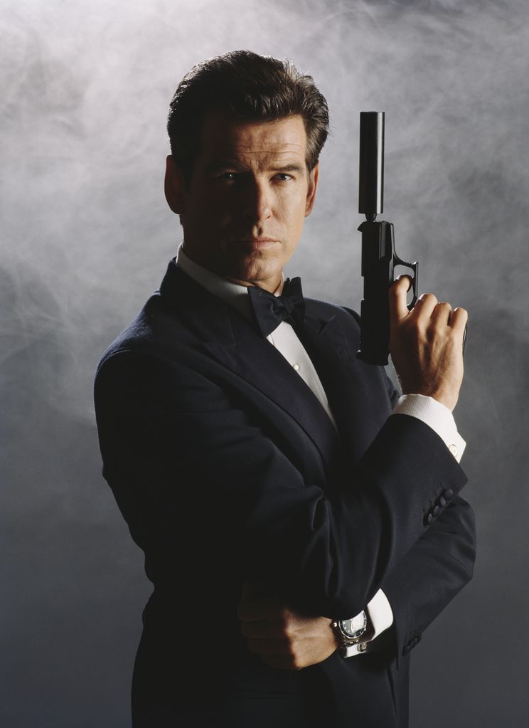 Pierce Brosnan as James Bond in a black tuxedo and carrying a gun