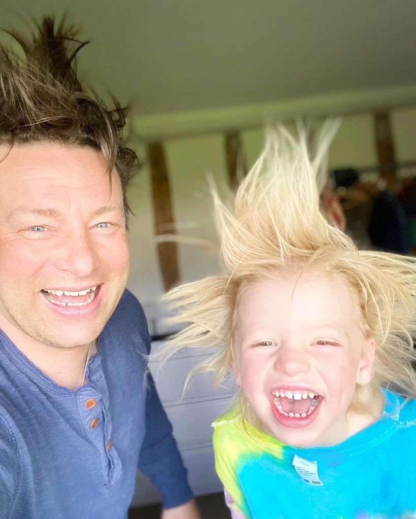 Jamie Oliver and his son River smiling with their hair standing on end
