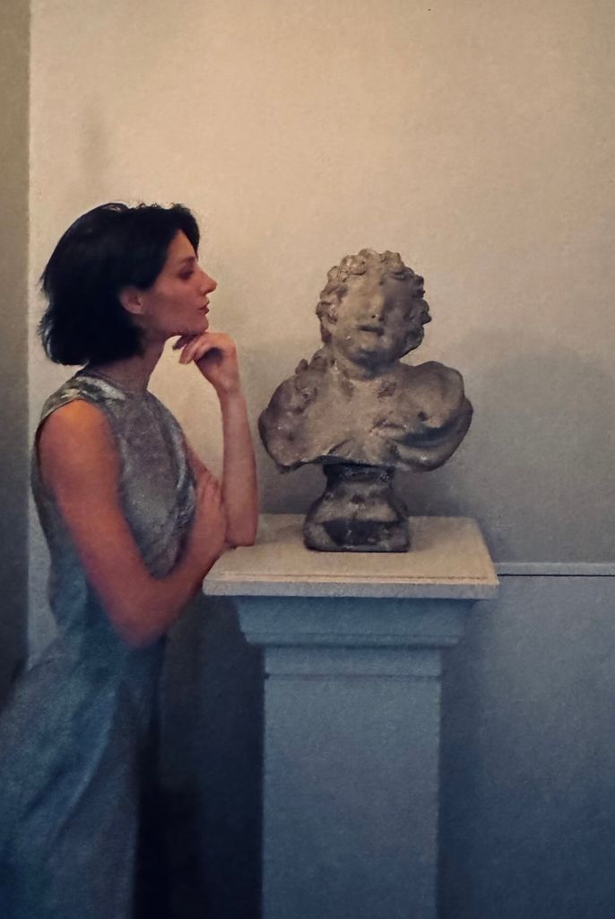 Audrey with short bob looking at statue