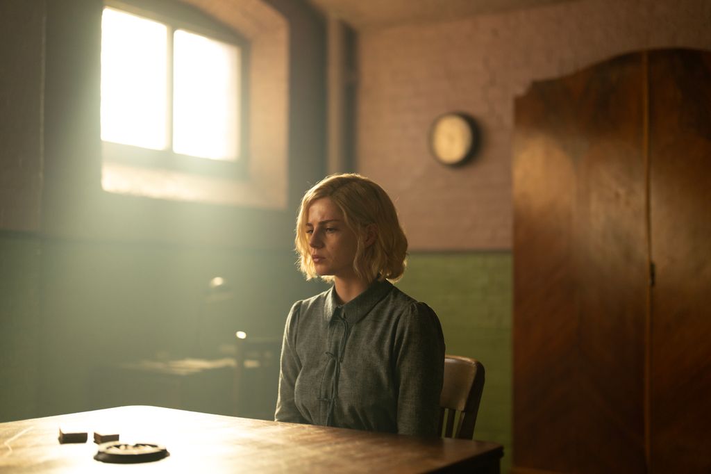 Blonde woman sitting in prison cell