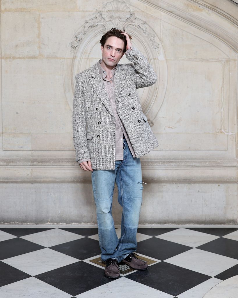 Robert Pattinson wears a grey double breasted blazer and jeans