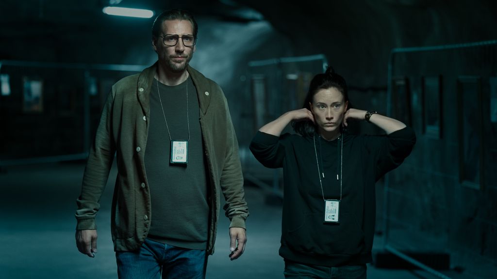 Nom du drame criminel en 6 parties de Channel 4 de Channel 4: Annika sonne digne de la binge 2 Homme et femme marchant dans une pièce faiblement éclairée