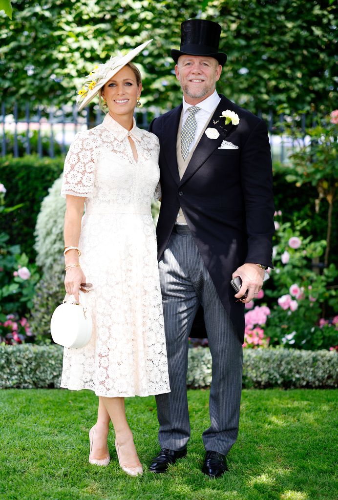 Zara Tindall in white dress and hat and Mike Tindall on grass in suit