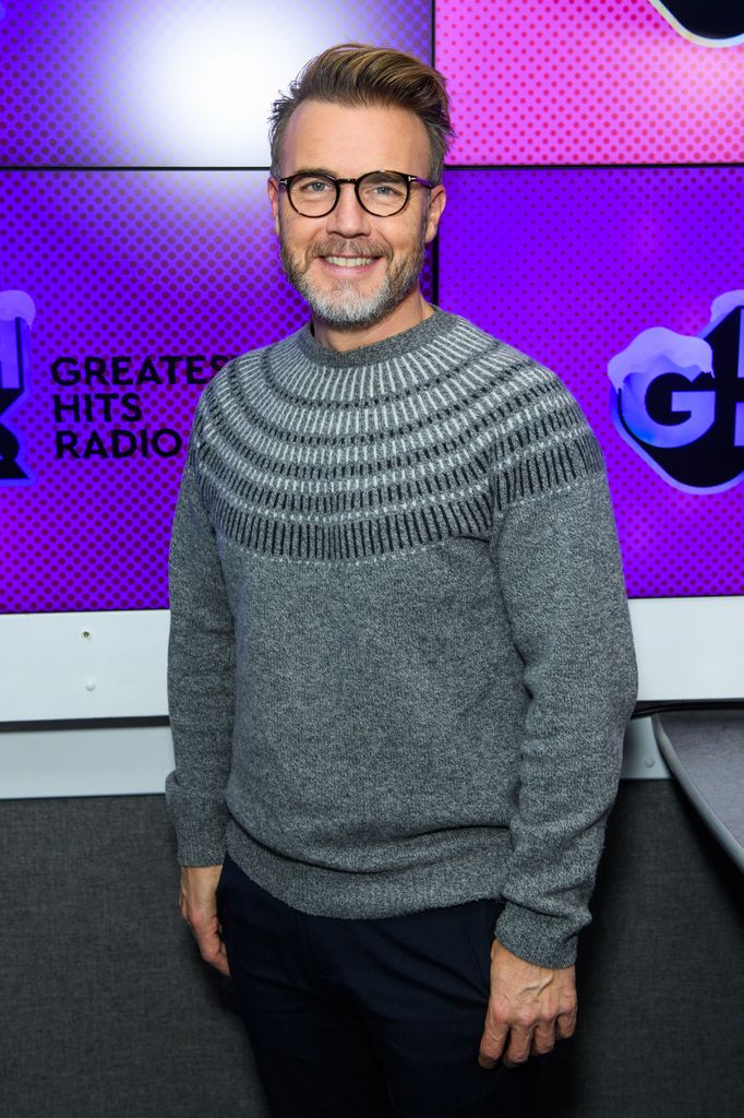 man posing in grey jumper and glasses