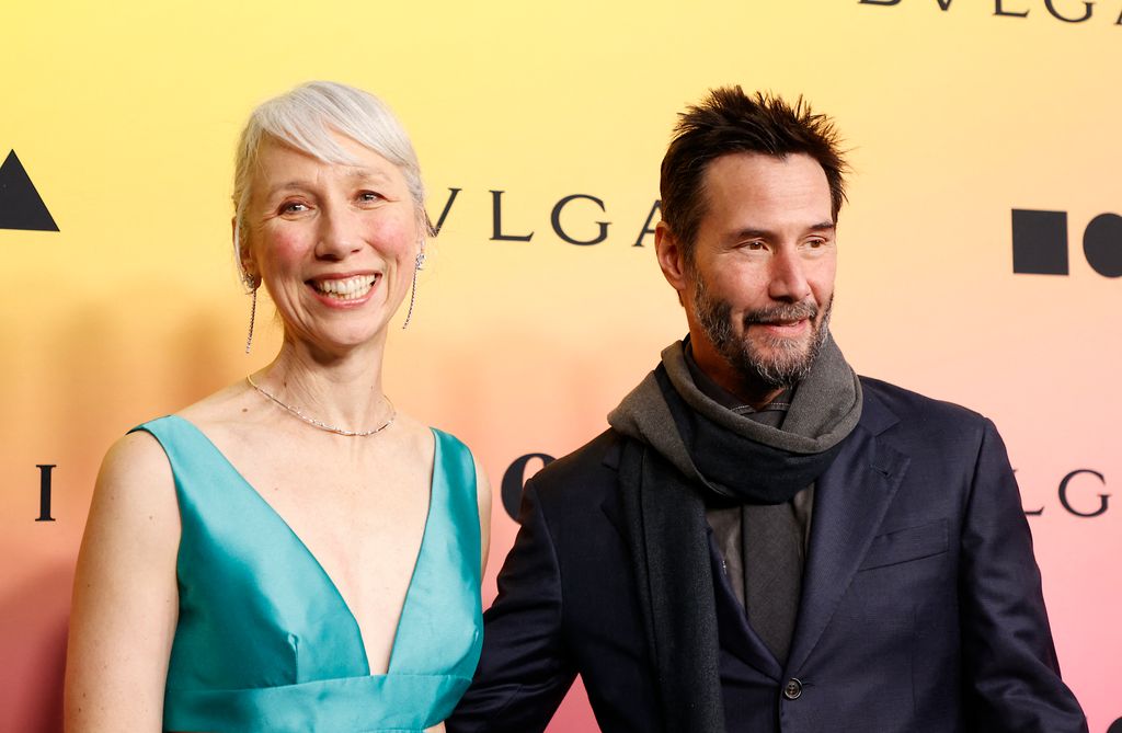 Alexanda Grant in a blue dress and Keanu Reeves in a blue suit