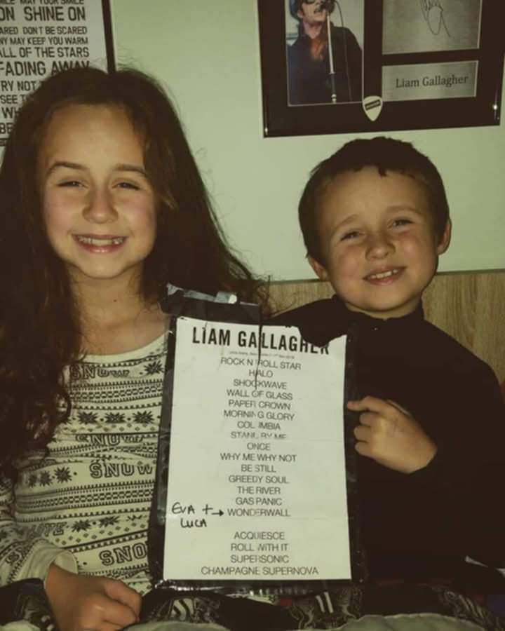 Luca Flynn and his sister holding up set list poster 