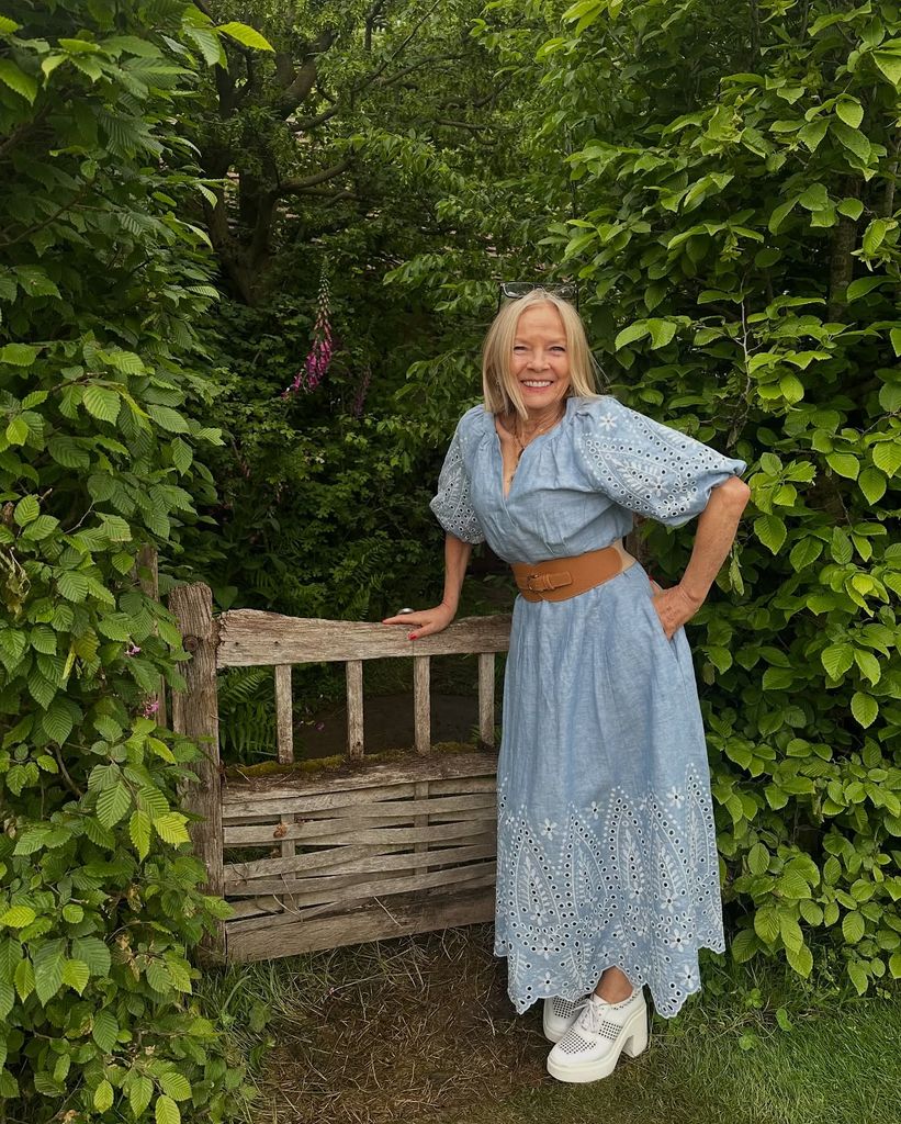Femme en robe en jean avec une large ceinture 