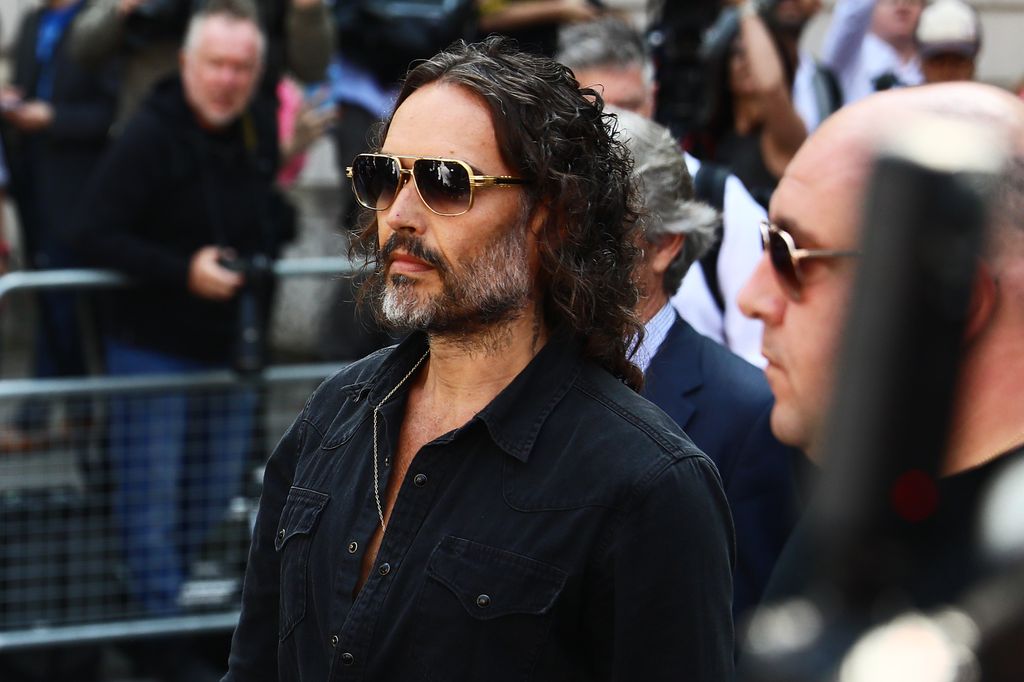 Russell Brand wit ha group of people walking towards court