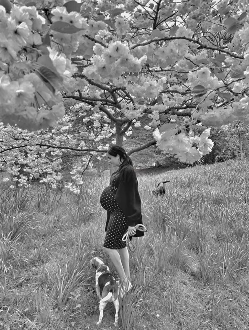 Pregnant Meghan Markle poses under a cherry blossom tree