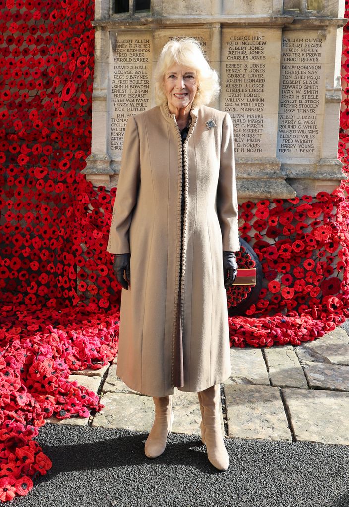 Queen Camilla smiles after she attached the final poppy to complete the cascade of 10,000 poppies draping the church tower