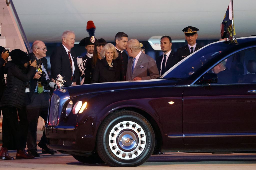 Queen Camilla and King Charles by a car