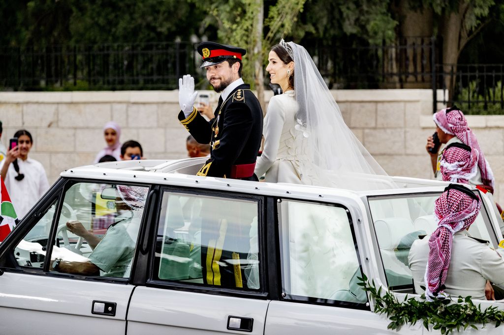 Princess Rajwa and Prince Hussein on a Range Rover after their wedding ceremony