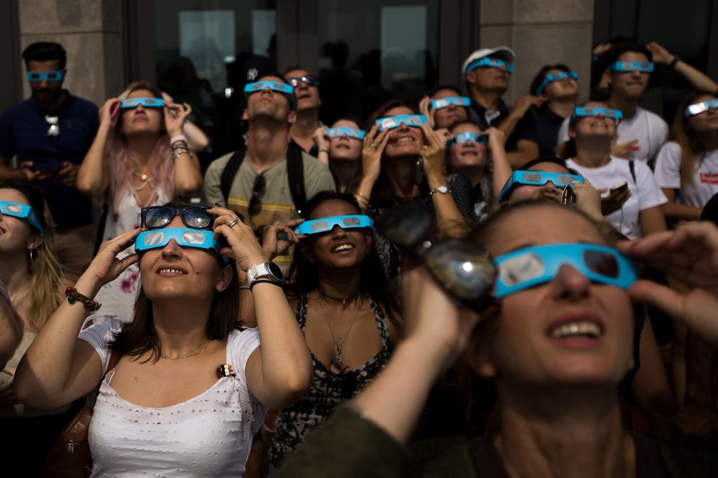 People view the solar eclipse at 'Top of the Rock' observatory at Rockefeller Center, August 21, 2017 in New York City