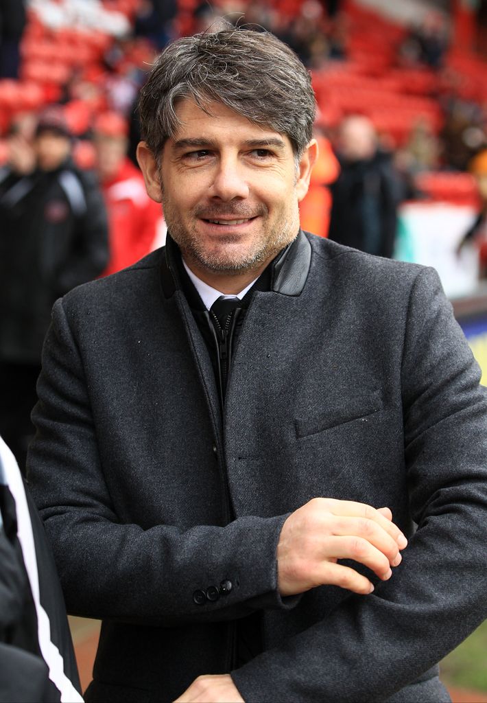  Paul Peschisolido in grey coat on football pitch