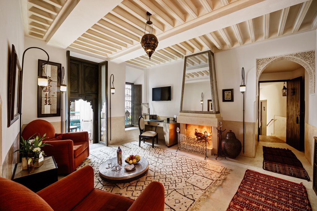 Le Farnatchi riad in Marrakech suite with fireplace and arm chairs 