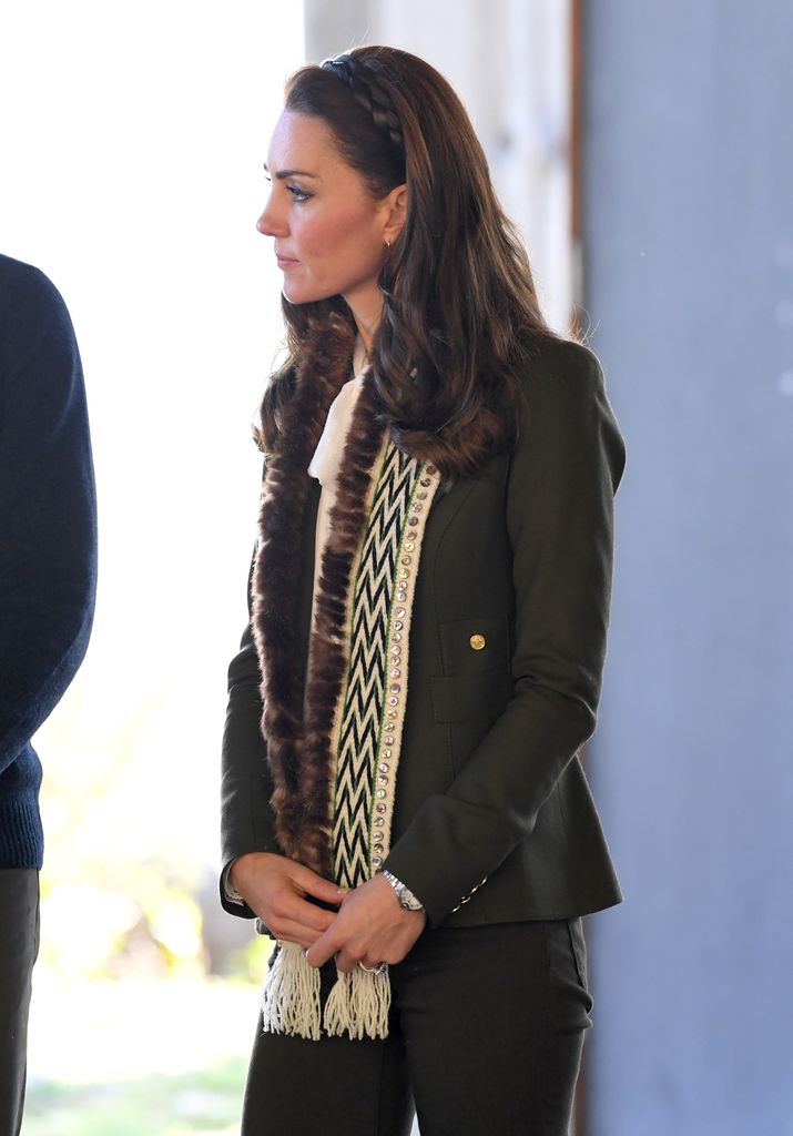 Kate side on wearing dark green blazer