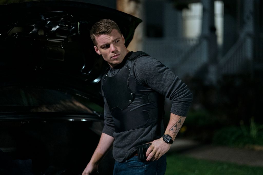 Gabriel Basso stands by car in The Night Agent 