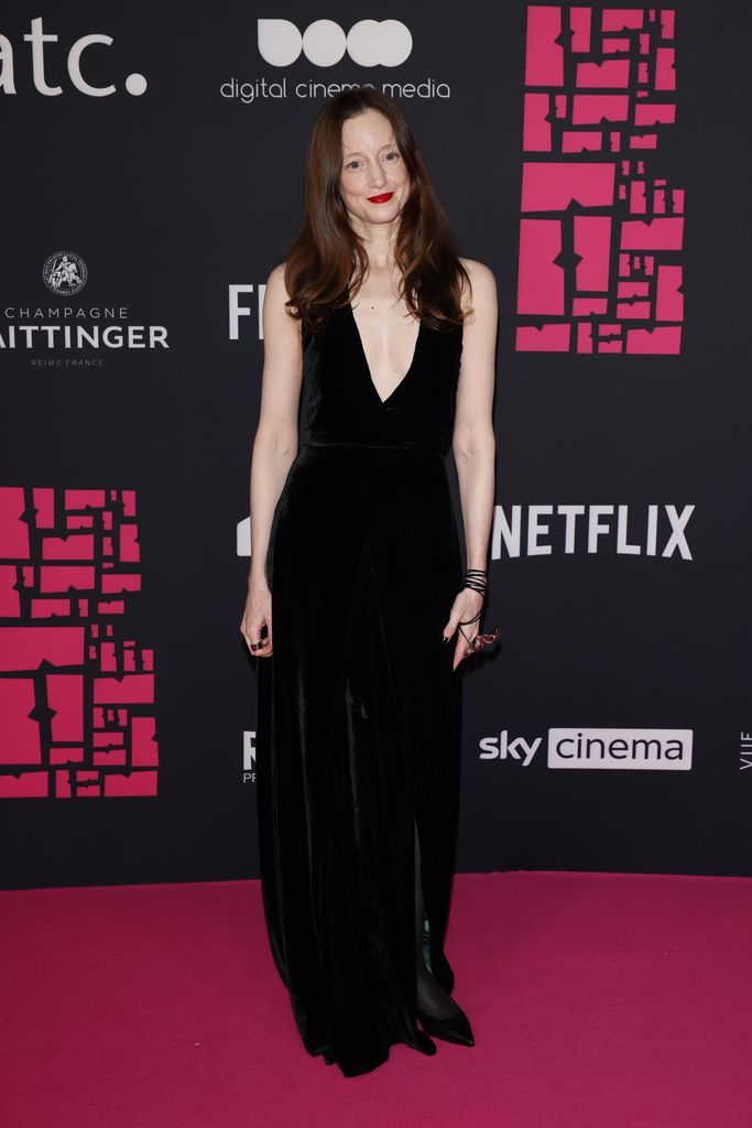 Andrea Riseborough on pink carpet in black dress