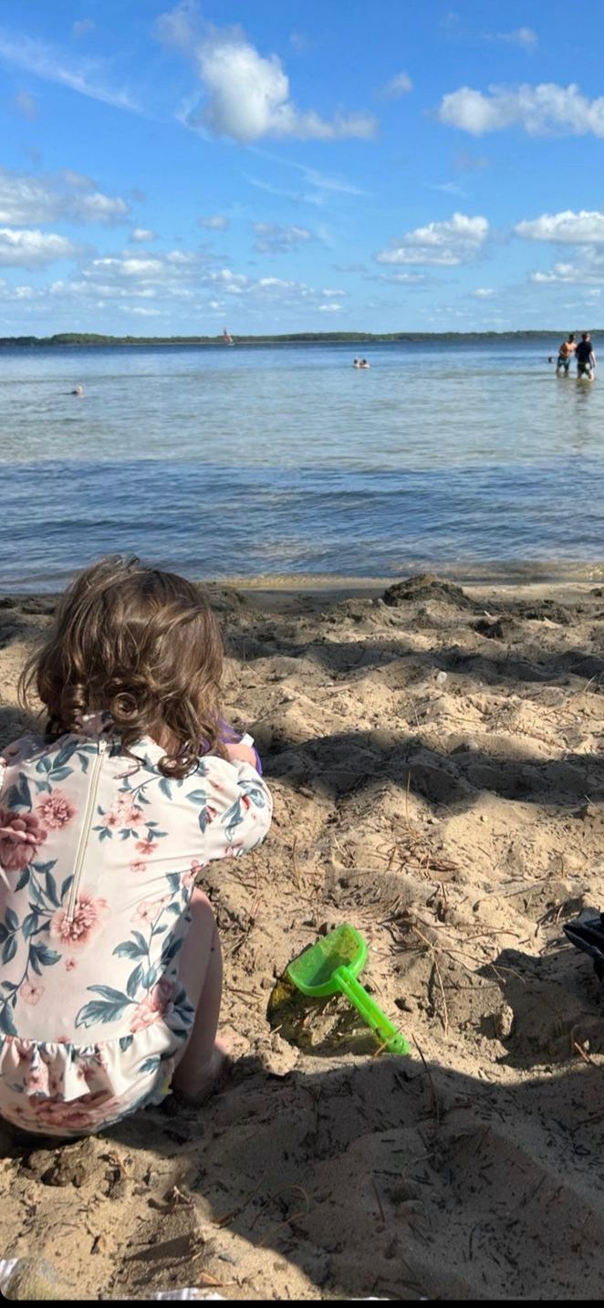 Alex Jones' daughter playing on the beach in a floral outfit