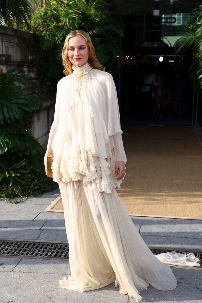 Diane Kruger at the fancy event, wearing a frothy layered cream layered dress, her blonde hair in tumbling tousled waves