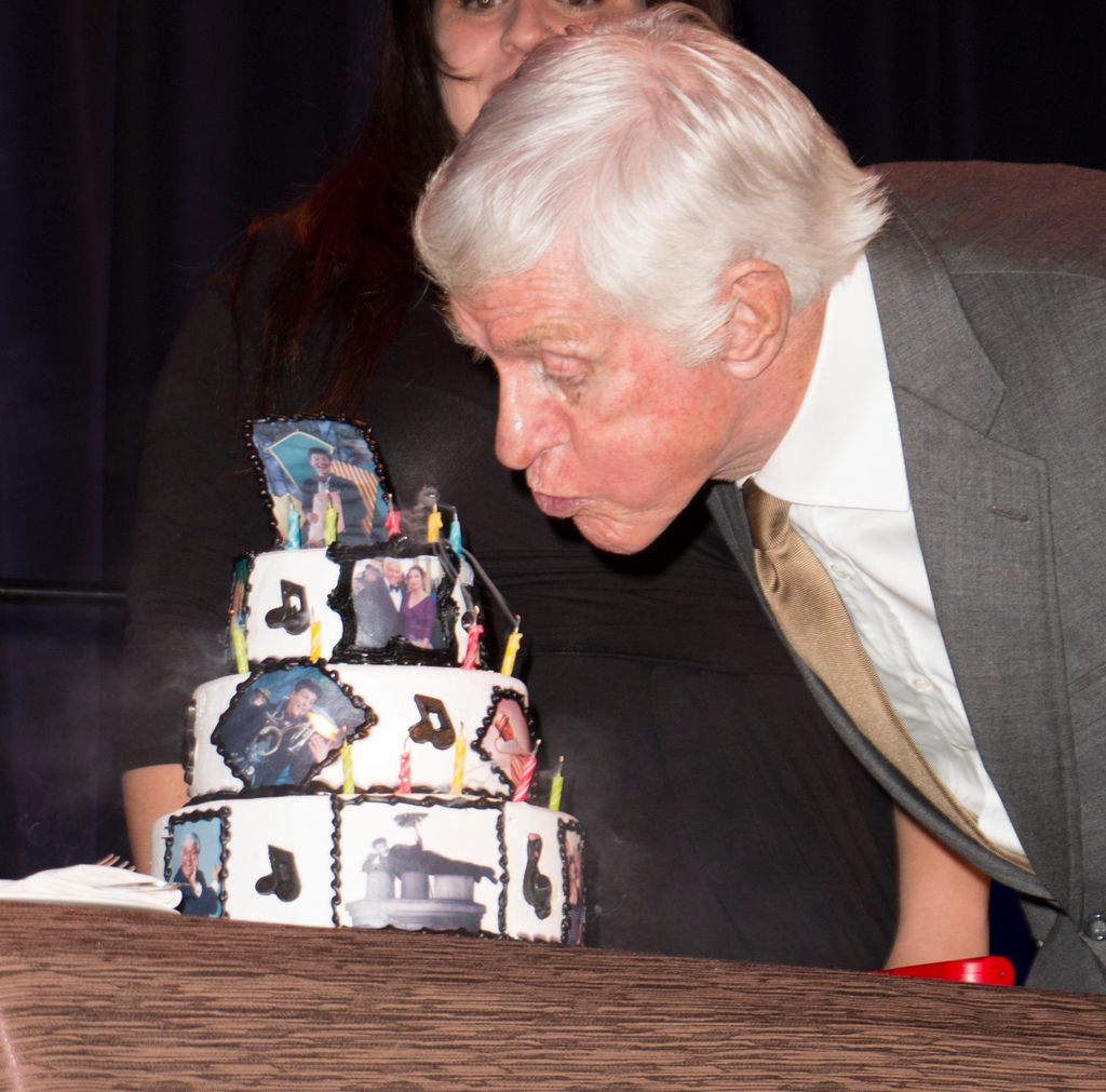 Actor Dick Van Dyke blows out candles on cake during his 90th birthday surprise presented by his wife Arlene Van Dyke at The Midnight Mission's Golden Heart Awards Gala in 2015