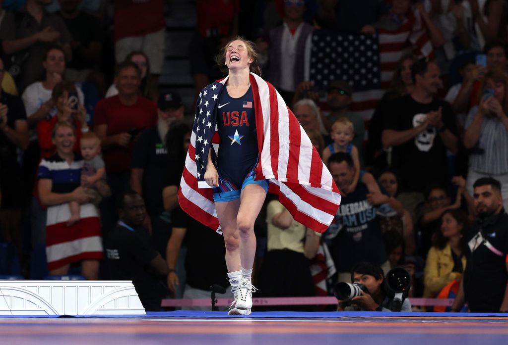 Sarah Ann Hildebrandt of Team United States celebrates with the United States flag following victory in the Wrestling Womenâs Freestyle 50kg Gold Medal match against Yusneylis Guzman Lopez of Team Cuba on day twelve of the Olympic Games Paris 2024 at Champs-de-Mars Arena on August 07, 2024 in Paris, France.