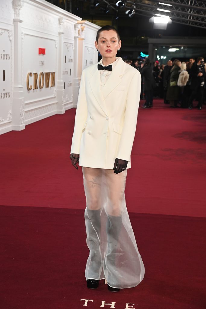 Emma Corrin in white suit jacket and sheer trousers