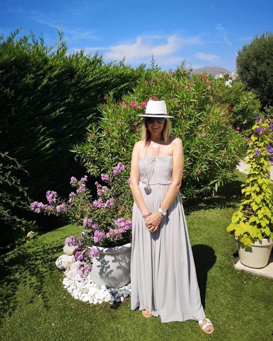 carol mcgiffin in garden wearing a dress and hat 