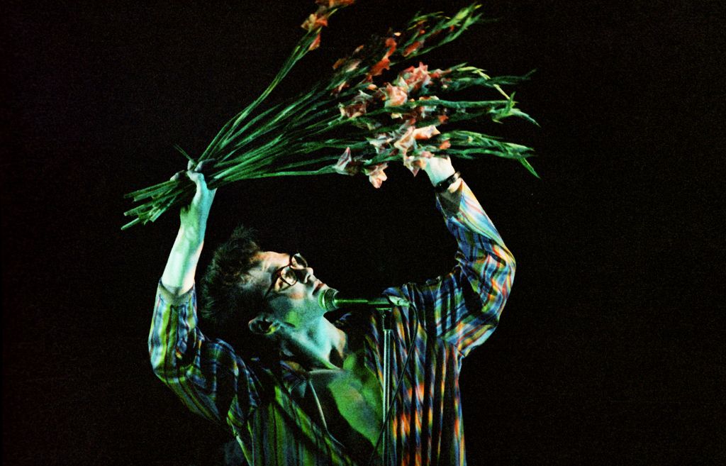 LONDON, UNITED KINGDOM - MARCH 12: Morrissey of The Smiths waves a bunch of gladioli while performing on stage at Hammersmith Palais, on March 12th, 1984 in London, England. (Photo by Pete Still/Redferns)