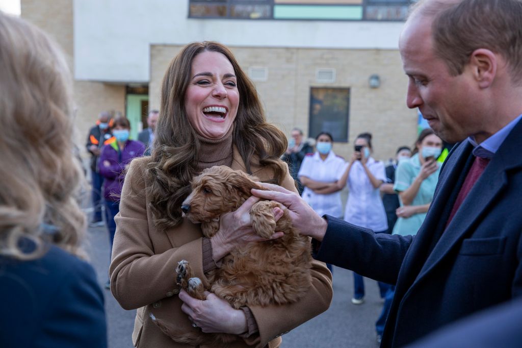 Kate holding puppy laughing with william