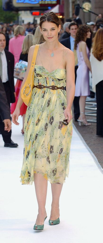 Katie Holmes wears a strappy green, brown and yellow midi dress with brown braided belt, yellow handbag and green peeptoe heels