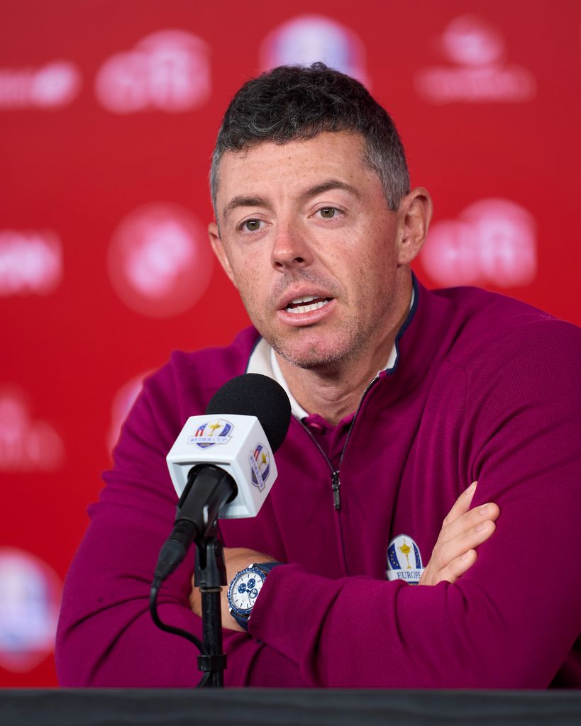 Rory McIlroy in purple top sits for a media interview prior to the Ryder Cup 2025 