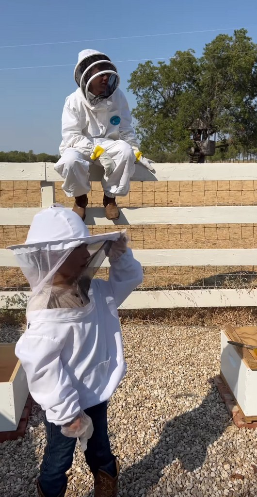 Still from a video shared by Joanna Gaines on Instagram August 2023 where she and her son Crew are wearing beekeeper suits, as they harvest honey in their farm.