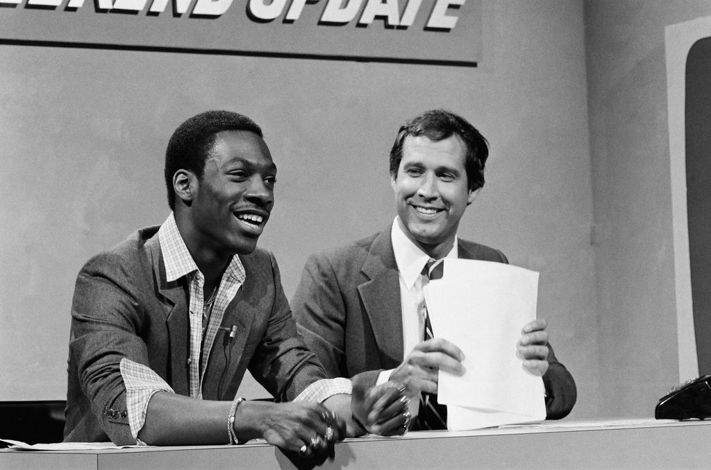 Eddie Murphy as Raheem Abdul Muhammed, Chevy Chase during "Weekend Update" on Saturday Night Live, April 11, 1981