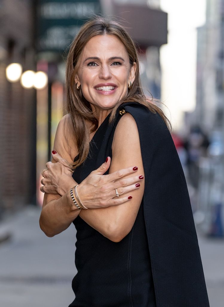 photo of jennifer garner shivering in black midi dress with a cape