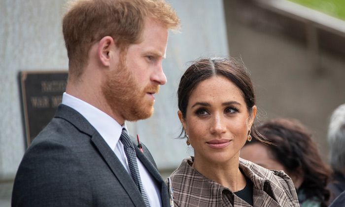 Meghan Markle looks up at Prince Harry while he looks concerned