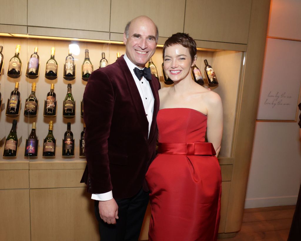 Emma Stone standing with a man at the Golden Globes after party