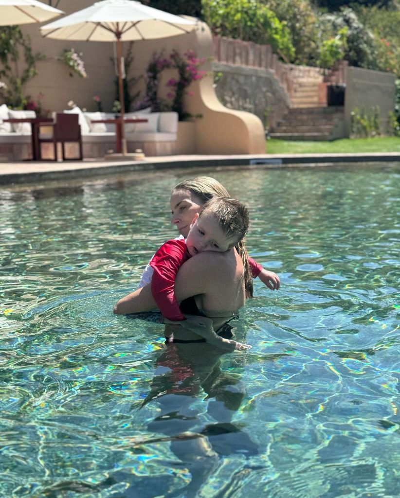 mother hugging son in swimming pool 