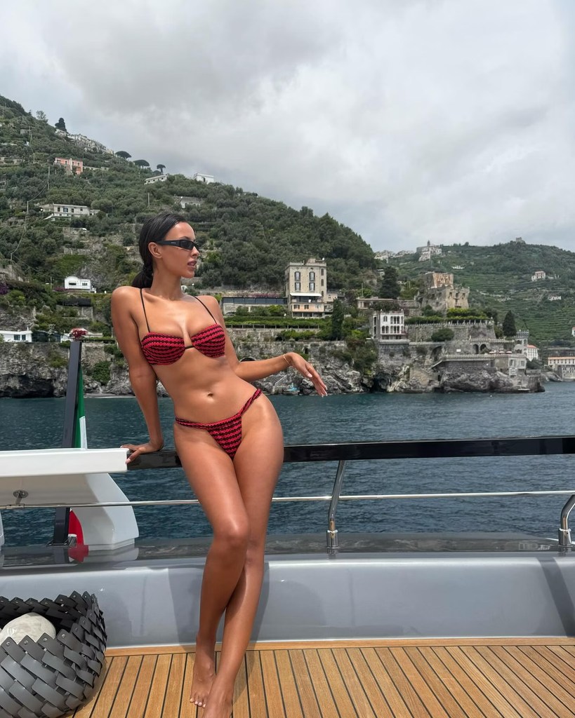 Maya Jama in a stunning red and black striped Triangl bikini posing on a yacht