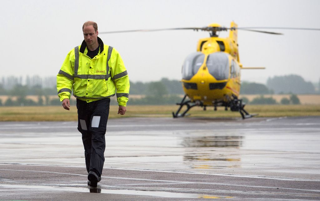 Prince William walking away from a yellow helicopter