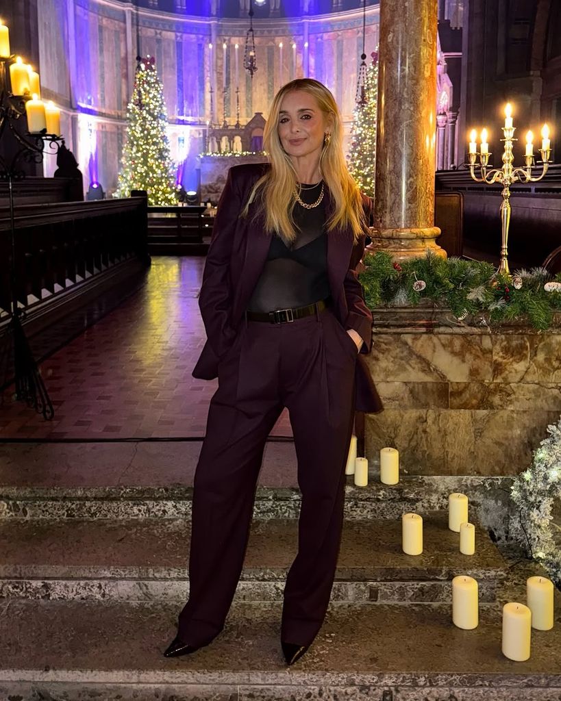 Louise Redknapp posing in a church in a burgundy suit