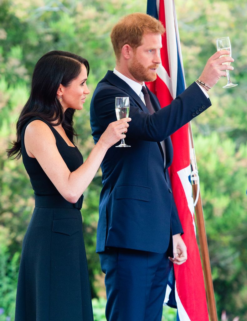 Meghan and harry cheersing with champagne flutes