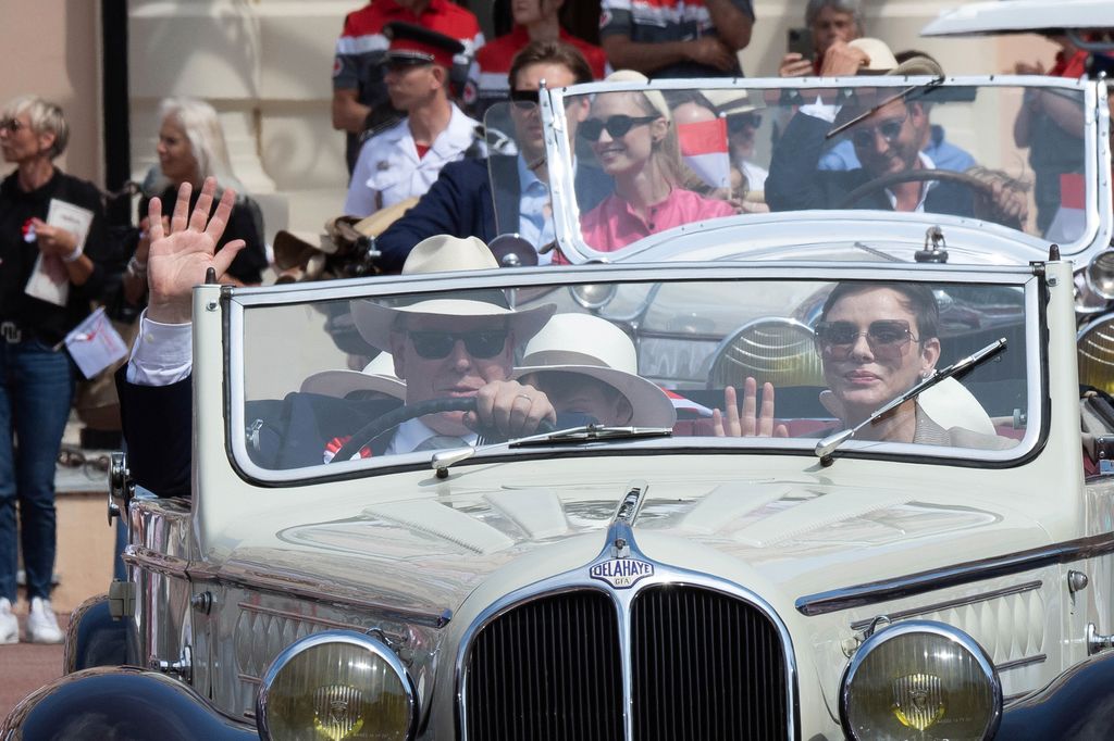 Princess Charlene of Monaco and Prince Albert II of Monaco along with other members of the royal family parade in vintage cars