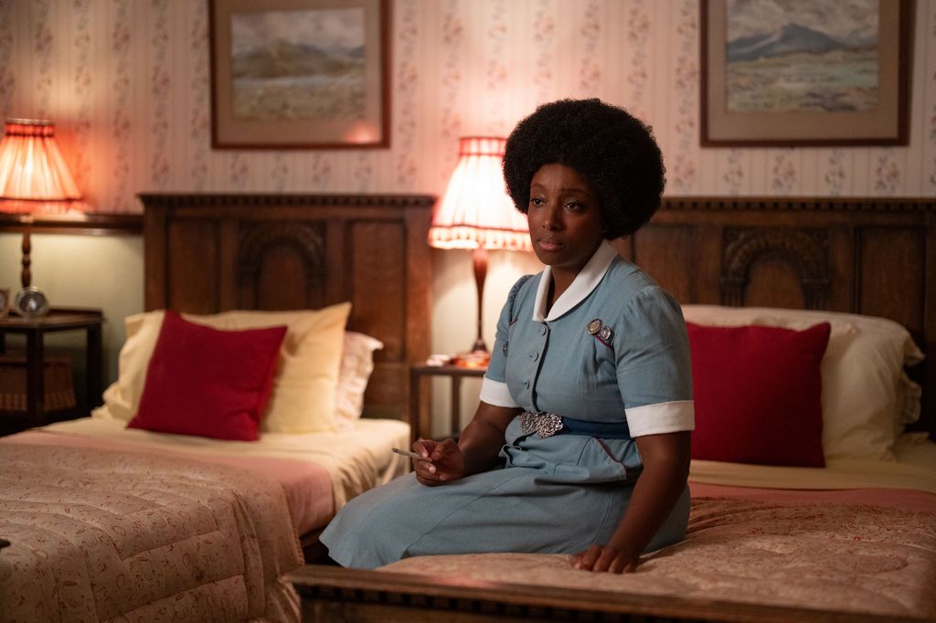 Woman in nurse uniform sitting on a bed