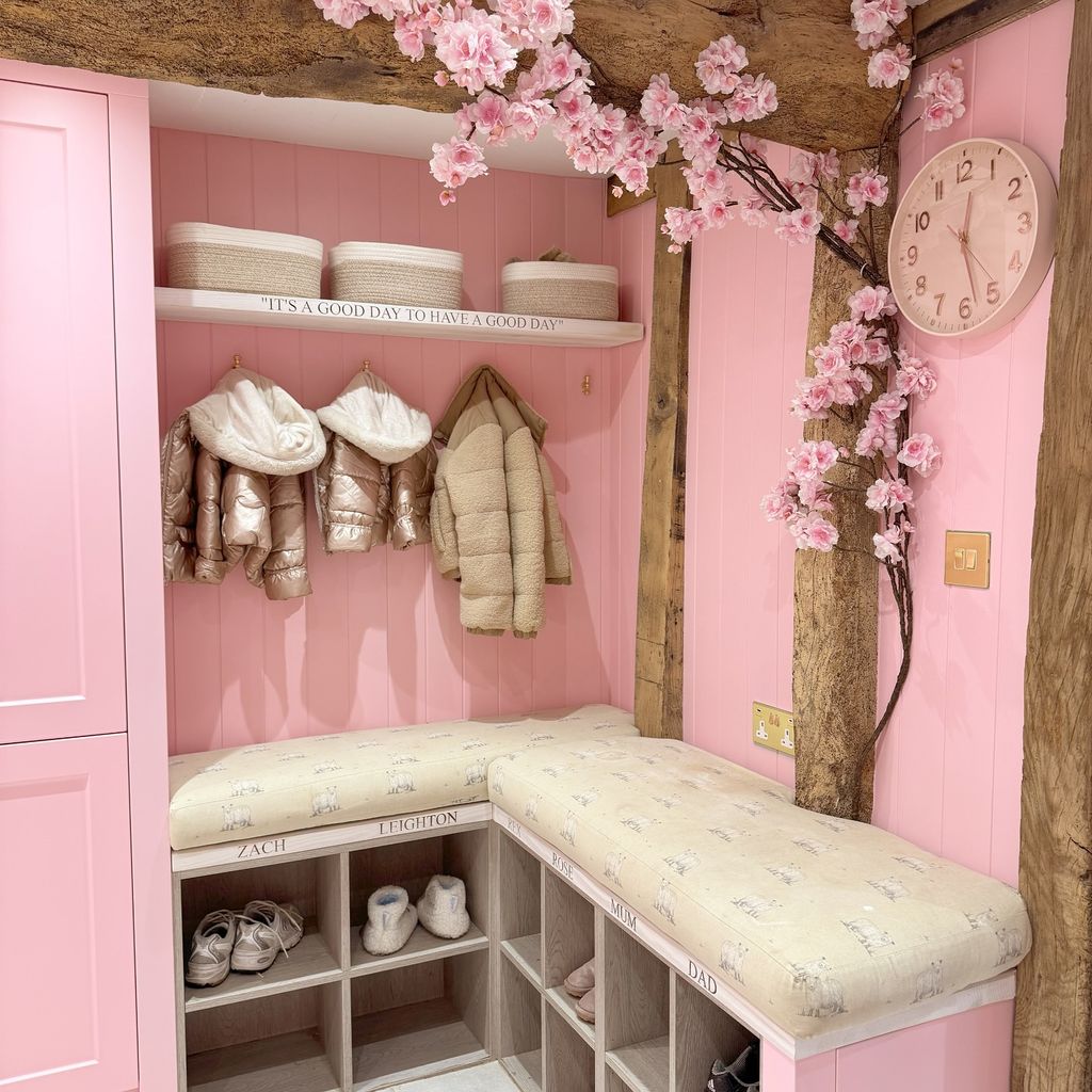 pink utility room cabinets with pegs with kids coat on