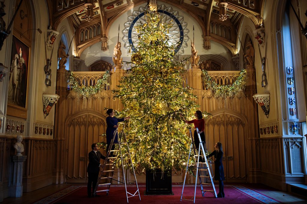 Employees pose with a 20ft Nordmann Fir tree from Windsor Great Park in St George's Hall which has been decorated for the Christmas period in November 2017