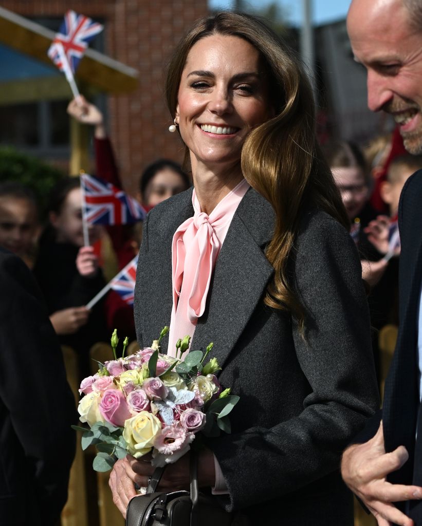 Kate wearing pink blouse and holding flowers
