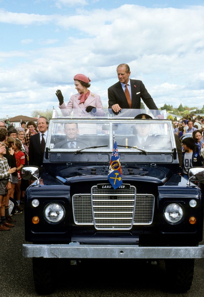 Queen Elizabeth II and Prince Philip, Duke of Edinburgh wave to wellwishers from their open Land Rover in Wellington, New Zealand, October 1981. 