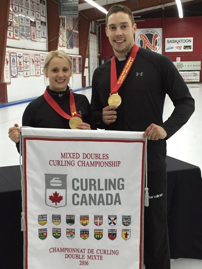 Jocelyn Peterman et Brett Gallant sourient et portent des médailles d'or tout en tenant une tapisserie du championnat de Curling Canada.