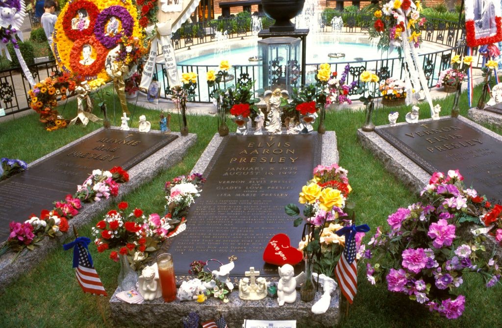 Photo of Elvis Presley's grave in between his mother and father's at Graceland.